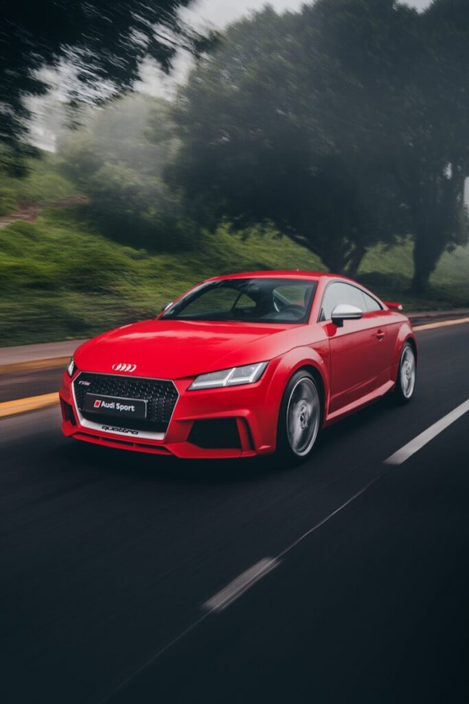 red Audi coupe on road near trees at daytime
